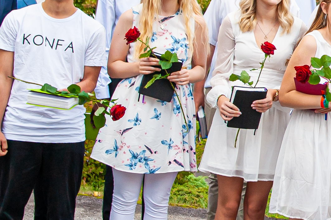 Konfirmander med rosor och biblar.