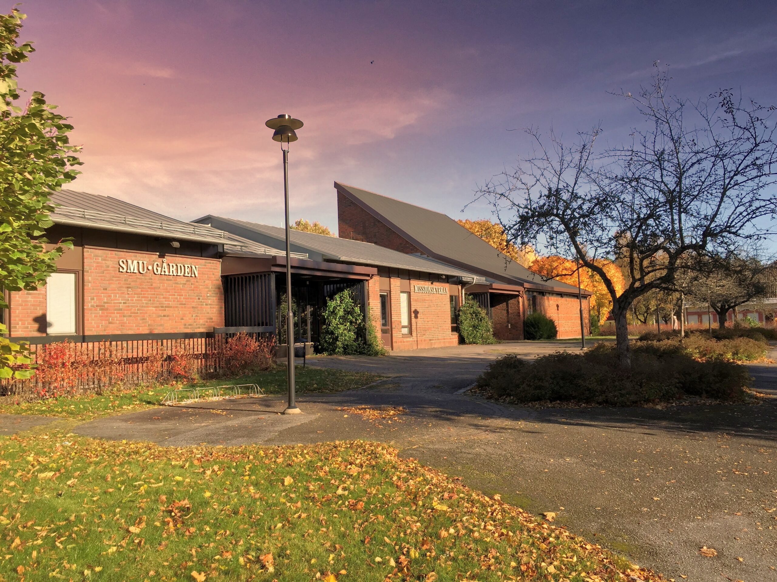 Bild på kyrkan utifrån, med gamla skyltarna för Missionskyrkan och SMU gården.